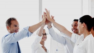 Happy business team giving high five