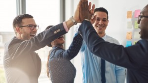 Happy successful business team giving high fives