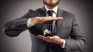 Boss holds caged man in hands