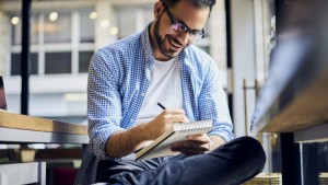 Man writing in note pad