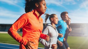 Young woman running with her team